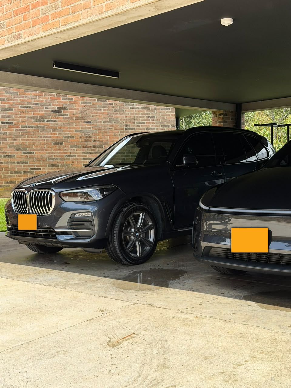 BMW X5 azul oscuro en un garaje de ladrillo